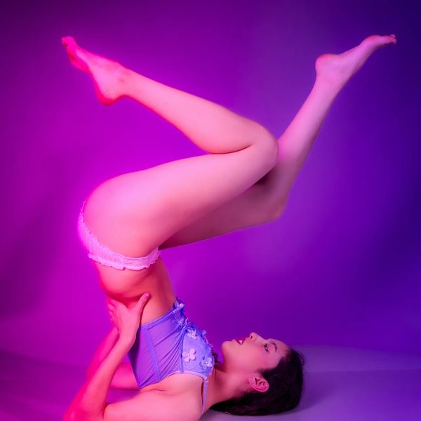 Woman in a graceful yoga pose with a purple accented border.